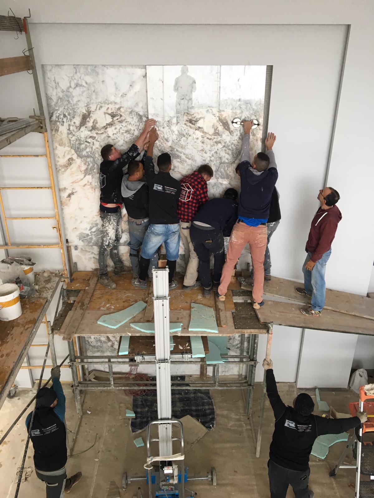 Equipa FarrelStones a instalar painel de mármore book-match